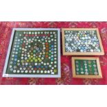 A large quantity of various golf ball markers, in three display cases.