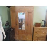 A 19th century Continental pine wardrobe, having central mirror door flanked by two panelled doors,