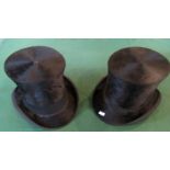 Two black felt top hats.