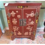 A contemporary two door cabinet, decorated in the Oriental manner.