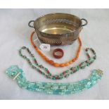 A silver plated twin handled dish containing amber coloured necklace and two other necklaces.