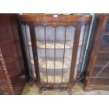 An Edwardian walnut glazed fronted china cabinet, having single door on ball and claw supports.