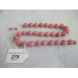 A pink bead necklace and a pair of matching earrings.