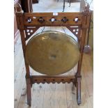 An Arts & Crafts oak framed brass dinner gong in the Pugin style.