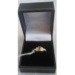 A seven stone half-hoop sapphire and diamond ring, the oval orange sapphire in raised claw mount,