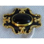 A Victorian gold and enamel mourning brooch, in a stylized form.