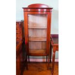 An Edwardian mahogany and inlaid glazed bow fronted china cabinet, on slender tapering supports.