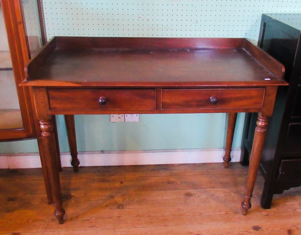 A Victorian mahogany two drawer washstand on ring turned supports.
