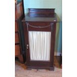 An Edwardian mahogany music cabinet, having swag decoration above a glazed door.