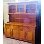 A 20th century pine dresser, the upper section having central glazed panel door,