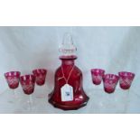 A cranberry bell shaped decanter, together with six liqueur glasses.