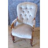 An Edwardian oak framed and upholstered fireside chair.