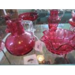 A collection of twelve pieces of cranberry glass, to include: candlesticks, bon bon dish,