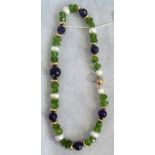 An amethyst peridot freshwater pearl necklace, the rough cut stones with gold bead spacers.