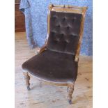 An Edwardian oak framed library chair, with brown draylon upholstery on turned and fluted supports.