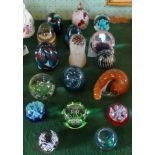 A collection of sixteen glass paperweights, various sizes, shapes and makers,