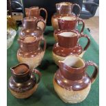 A collection of eight Doulton Lambeth harvest jugs, various sizes.