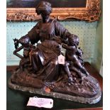 A late 19th century brown patinated bronze figural group, modelled as a muse, flanked by putti,