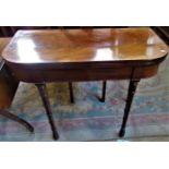 A Victorian mahogany fold-over card table on ring turned supports.