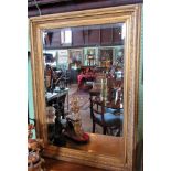 A large 20th century carved and gilt framed wall mirror, with central bevelled plate.