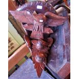 An early 20th century carved corner shelf in the form of an eagle.