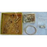 An assortment of gold earrings, rings, a gold bangle, bracelet and other items.