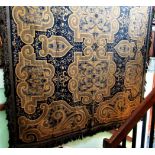 A large patterned carpet with gold swirl decoration on a blue ground, 140 x 102cm.