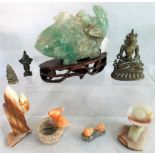 A large jade carving of a fish on wooden stand, together with other carvings.