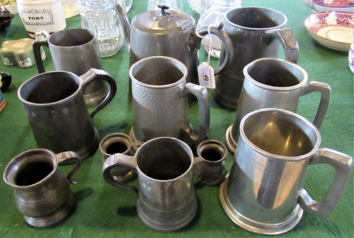 A quantity of pewter tankards and other related items.