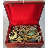 A leather box containing a quantity of costume jewellery to include: brooches, earrings,