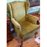 A 20th century wing armchair in green draylon.