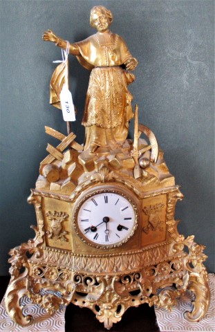 A 19th century French ormolu mantle clock the enamel dial below a cleric lamenting revolution.