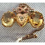 A gold brooch with central pearl set heart, flanked with oval claw mounted citrine stones,