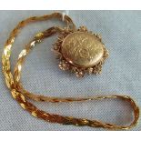 A 9ct gold twisted two strand herringbone necklace and a 9ct gold foliate engraved locket.