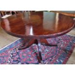 A large circular Victorian mahogany tilt-top table on central column and quadruple base,