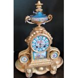 A 19th century ormolu mantle clock, having twin handled and ceramic urn surmount,