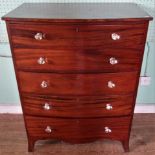 A mahogany bow front chest of five long drawers.