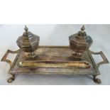 A silver desk set the twin handled stand with two fixed octagonal inkwells with otter and fish