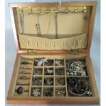 A wooden box containing a quantity of silver and white metal jewellery to include: rings, earrings,