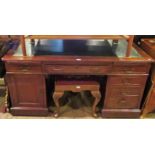 An Edwardian mahogany partners desk, having an inset tooled leather scriber,