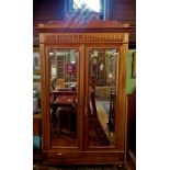 A large 20th century Continental oak two door mirror wardrobe, with carved super structure,