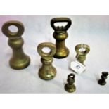 A set of six graduated brass postal weights.