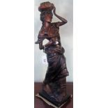 A contemporary bronze figure of a young lady carrying fruit.