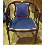 An Edwardian beech framed and upholstered tub chair.