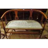 An Edwardian mahogany framed inlaid and upholstered blue seat salon settee.