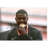 Justin Gatlin signed 12x8 colour photo. American sprinter who specializes in the 100 and 200