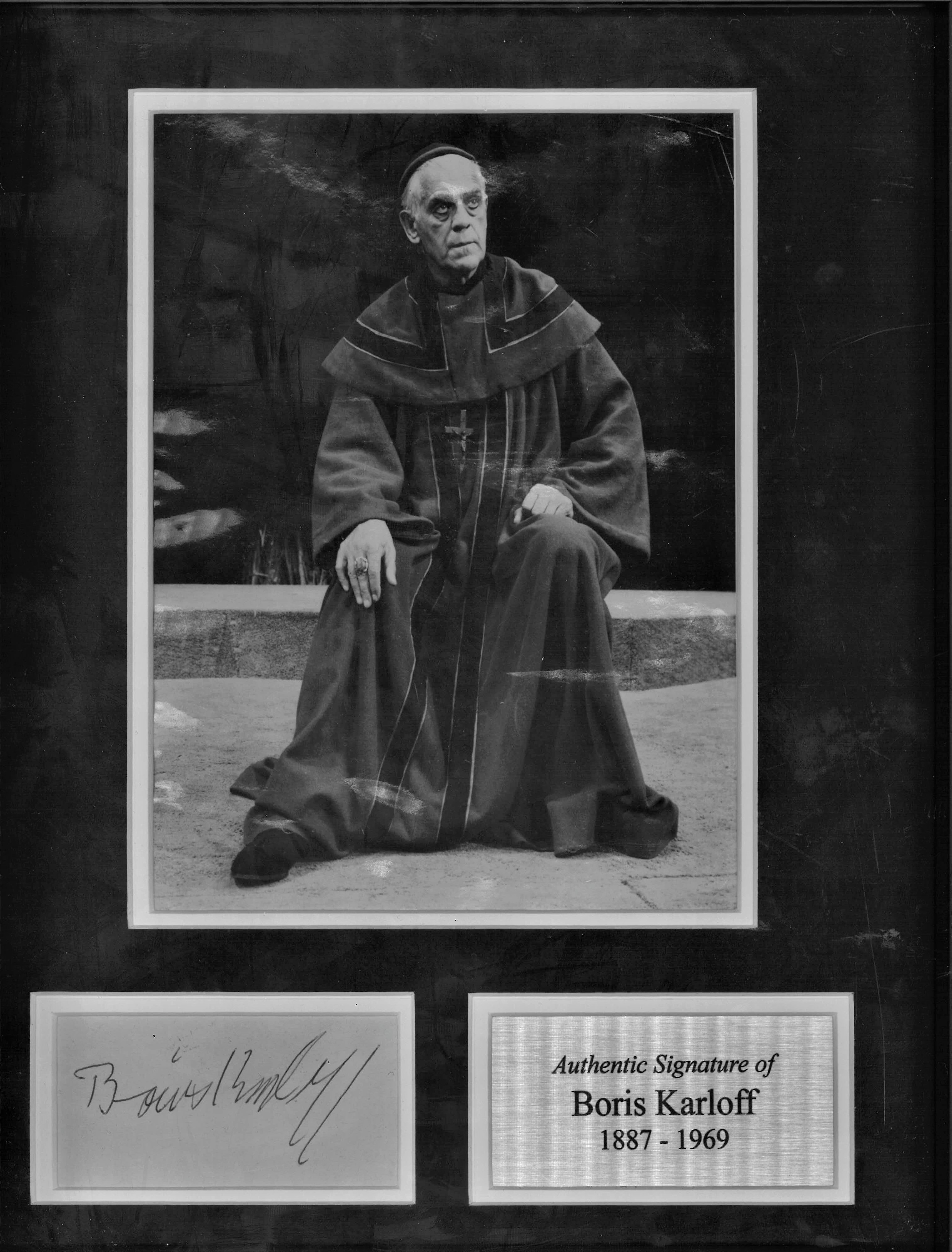 Boris Karloff signature piece mounted and framed below b/w photo with a silver plaque alongside.