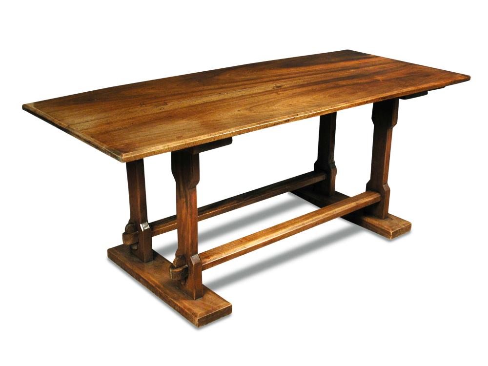 An Arts & Crafts walnut refectory table, the rectangular top supported to either end by a pair of