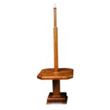 An Art Deco walnut standard lamp table, the square column above a square table with canted corners