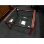 In the manner of Jacques Adnet, a glass-topped leather framed coffee table, the square plate glass